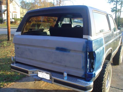 1984 Ford Bronco - This Ford Bronco appears to be undergoing bodywork, with its tailgate primed and one taillight missing.