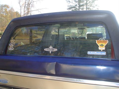 1984 Ford Bronco - 1984 Ford Bronco rear window displays multiple stickers, including 'Cowboy Up' and '10 Years Trail Tough'.