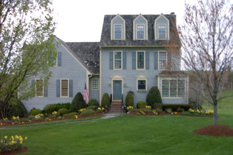 1996 Mercury Grand Marquis - A suburban house with manicured landscaping and a large front lawn.
