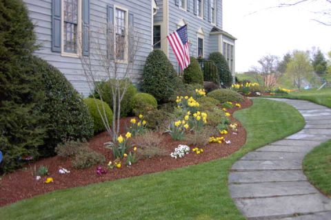 1996 Mercury Grand Marquis - A well-maintained house features a vibrant flower garden and a winding stone pathway leading through the lawn.