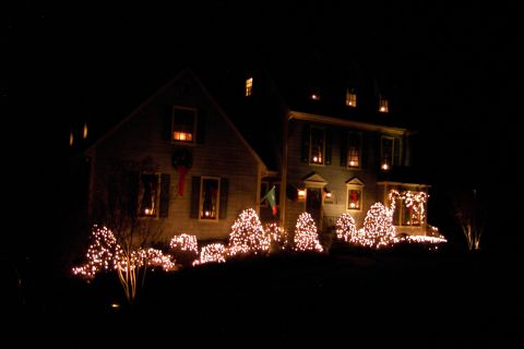 1996 Mercury Grand Marquis - A house is illuminated by Christmas lights on its exterior and landscaping at night.