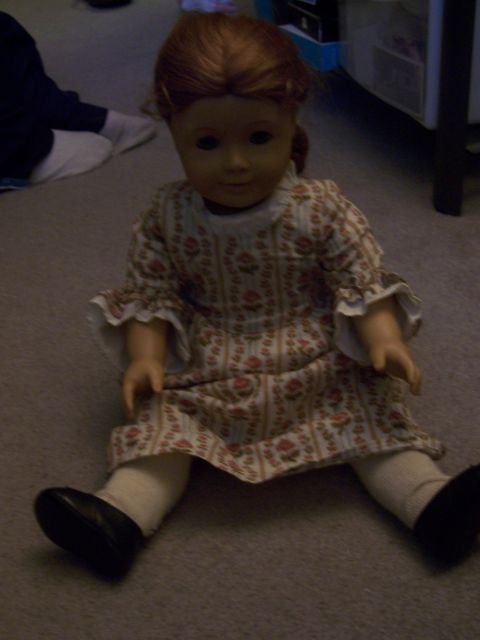 1987 Volkswagen Golf - Doll sitting on carpet, wearing a vintage-style dress and black shoes.