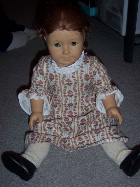 1987 Volkswagen Golf - A doll dressed in a colonial-style floral print dress sits on a carpeted floor.