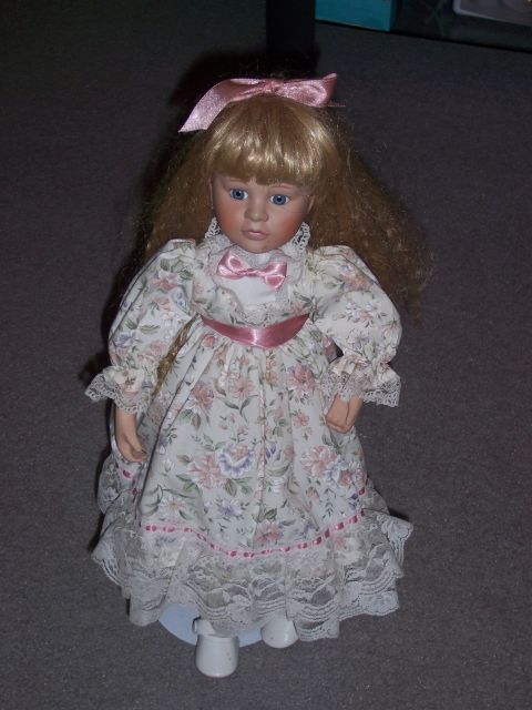 1987 Volkswagen Golf - This is a porcelain doll dressed in a floral print gown with lace trim.