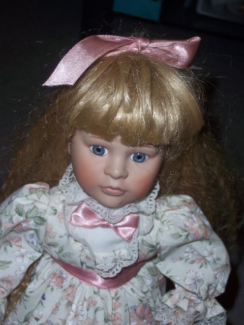 1987 Volkswagen Golf - This photo shows a porcelain doll wearing a floral dress and a pink bow in its hair.