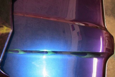 1968 Mercury Cougar - Custom paint job a metallic purple and blue finish with green flame pinstriping on a vehicle's fender.