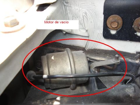 1986 Ford Bronco - Close-up view of a vacuum actuator component, labeled in Spanish as 'Motor de vacio'.