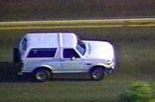 1986 Ford Bronco - This 1986 Ford Bronco is seen from the side, driving on a paved road.