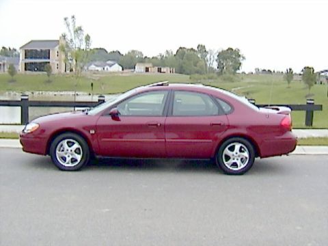 2002 Ford Taurus - A red sedan is shown from the side, with a sunroof and alloy wheels.