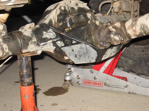 1977 Ford F-150 - Close-up of a heavily soiled vehicle differential and driveshaft assembly, supported by mechanical stands.