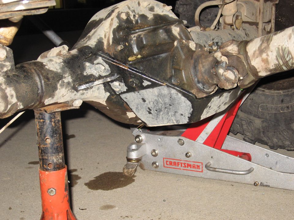 Dirty differential and driveshaft supported by jack stands and a floor jack