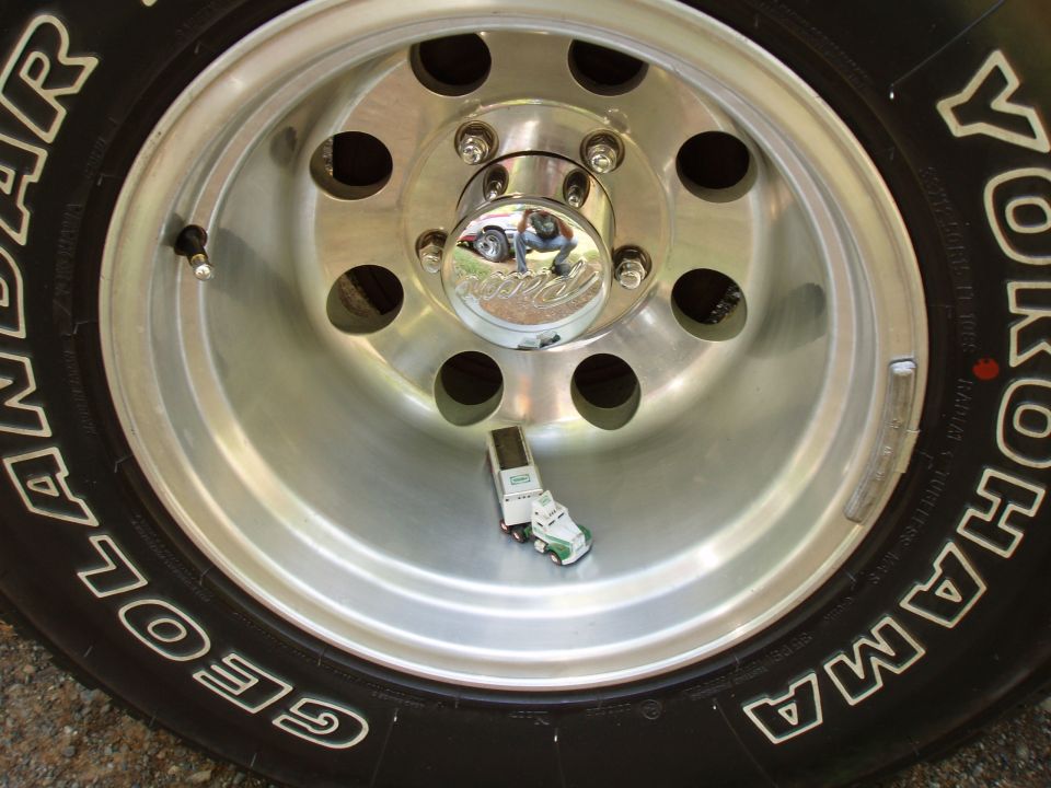 Close-up of a wheel with a toy truck and trailer inside the rim