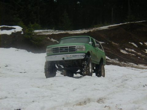 1994 Ford Explorer - This lifted SUV is equipped with large off-road tires and is navigating a snowy terrain.