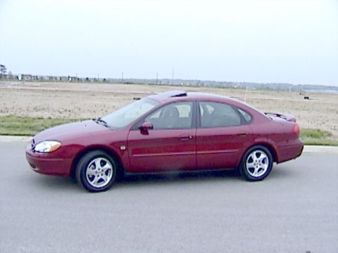 2002 Ford Taurus - This red sedan has a distinctive body style and alloy wheels.