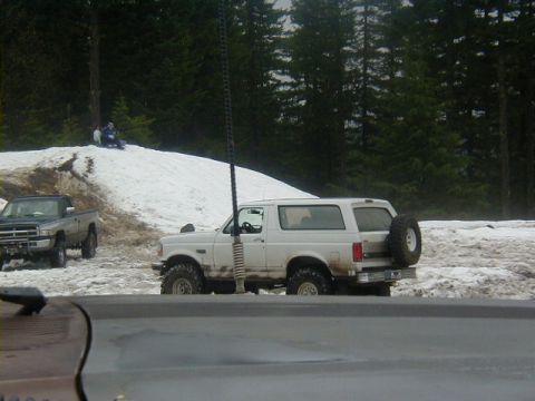 1994 Ford Explorer - Two off-road vehicles are parked in a snowy area with trees and a sledding hill in the background.