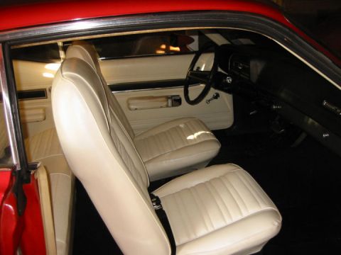 1972 Ford Ranchero - The interior of a 1972 Ford Ranchero features cream-colored bucket seats and a black dashboard.