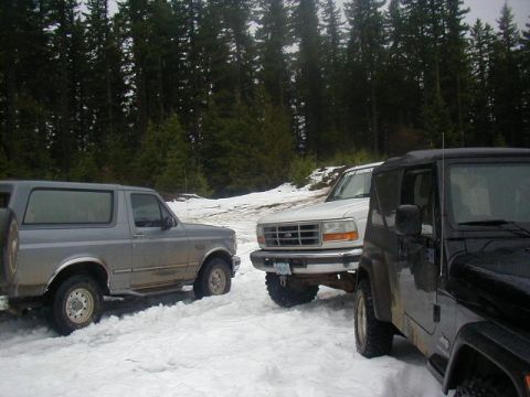 1994 Ford Explorer - Three SUVs are parked in a snowy area with trees in the background.