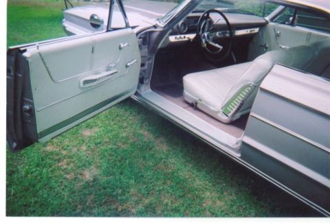 1972 Ford Ranchero - The interior of a 1962 Ford Galaxie convertible, showing the white seats and door panel with the door ajar.