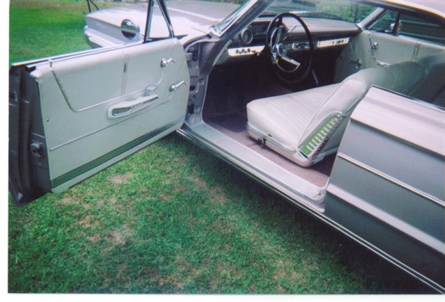 Interior view of a 1962 Ford Galaxie convertible with white seats and open door