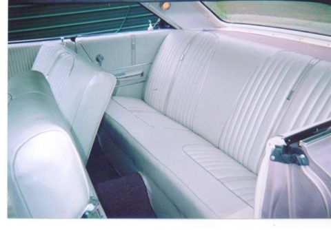 1972 Ford Ranchero - The interior of a car features light-colored bench seating and door panels.
