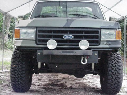 1991 Ford Bronco - Front view of a 1991 Ford Bronco with camouflage paint and a heavy-duty aftermarket bumper.