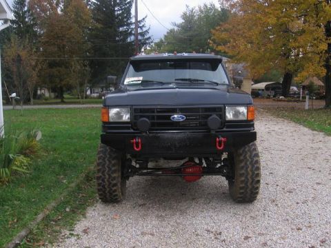 1991 Ford Bronco - Front view of a black Ford F-Series truck, likely from the late 1980s, with aftermarket modifications.