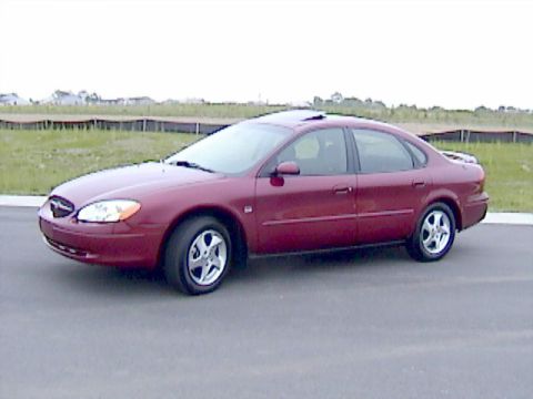 2002 Ford Taurus - A red sedan is shown from the front-side angle with its sunroof open.