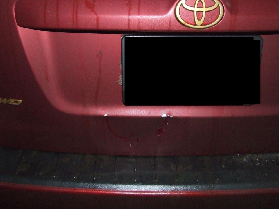 Red SUV rear bumper with Toyota logo and minor damage