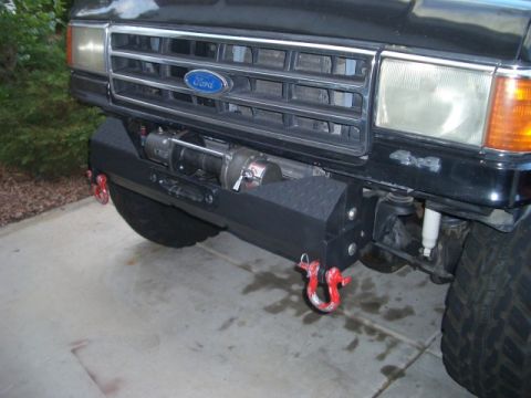 1991 Ford Bronco - Front view of a black 1991 Ford Bronco showing its custom bumper, winch, and 4x4 badging.