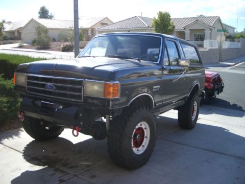 1991 Ford Bronco - This 1991 Ford Bronco features an aftermarket bumper and winch, with a red Jeep visible behind it.