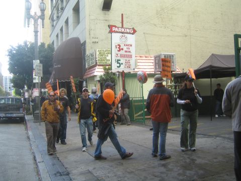 1990 Ford Bronco - Pedestrians with orange balloons walk along a downtown sidewalk near a Parking rate sign and restaurant marquee.