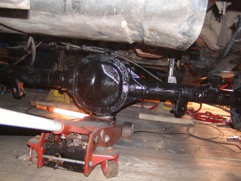 1991 Ford Bronco - Rear axle assembly being worked on, supported by a floor jack and jack stands.