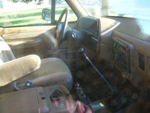 1992 Ford Bronco - The interior of this truck features a manual transmission and a tan dashboard.