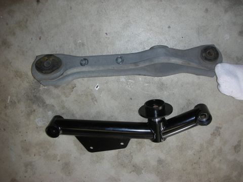 1990 Ford Mustang - Two car suspension control arms are laid out on a concrete surface, likely for a repair or replacement.