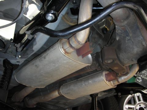 1990 Ford Mustang - Underbody view of a car's dual exhaust system and rear suspension components.