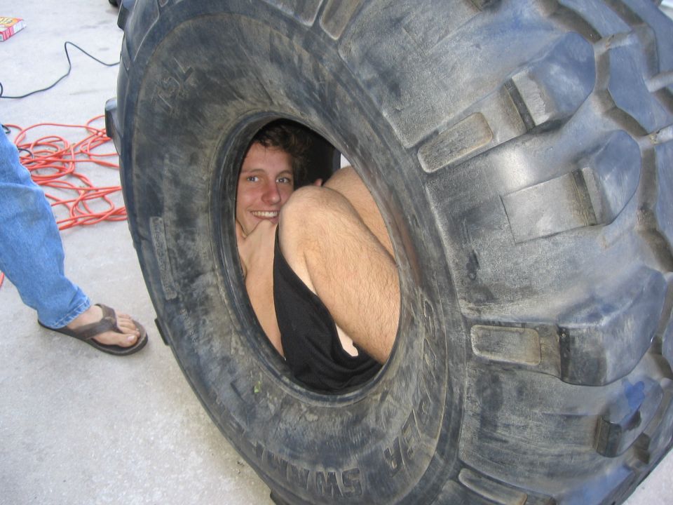 guy sitting inside a huge tire