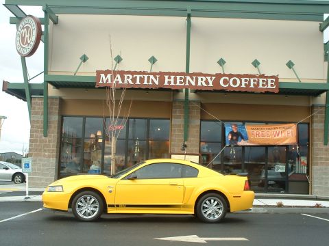 2000 Ford Crown Victoria - Yellow 2000 Ford Mustang parked in front of Martin Henry Coffee, which offers free Wi-Fi.