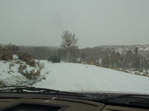 2003 Ford Ranger - A dark SUV navigates a snowy road during a winter day.