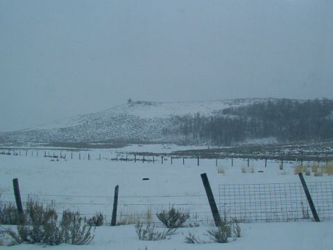 2003 Ford Ranger - A winter scene with snow-covered fields and a distant hill under a cloudy sky.