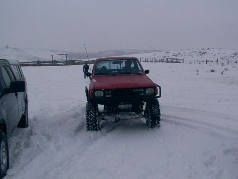 2003 Ford Ranger - Two trucks are parked in a snowy field with a person walking between them.