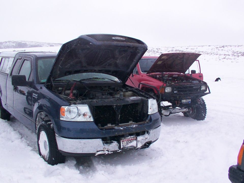 Blue pickup truck with hood open in snow, 2003 model year