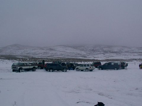 2003 Ford Ranger - A group of vehicles are parked in a snow-covered landscape with hills in the background.