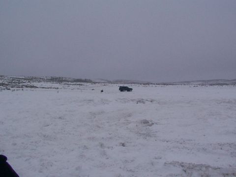 2003 Ford Ranger - A lone dark SUV is visible in the distance, surrounded by a desolate, snow-covered landscape on a cloudy day.