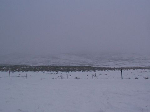 2003 Ford Ranger - A desolate winter scene with a fence line cutting across a snow-covered field and rolling hills in the background.
