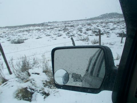 2003 Ford Ranger - Two trucks navigate a snowy landscape, viewed through the side mirror of another vehicle.