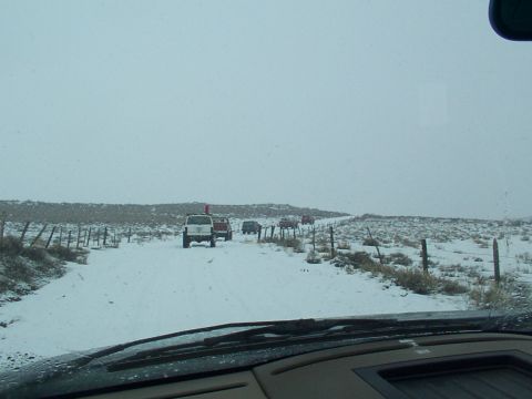 2003 Ford Ranger - A convoy of SUVs navigates a snowy path, with a fence line visible on the left and sparse vegetation on either side.