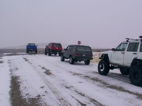 2003 Ford Ranger - Several off-road vehicles navigate a snowy path, with one vehicle in the foreground showing extensive modifications.