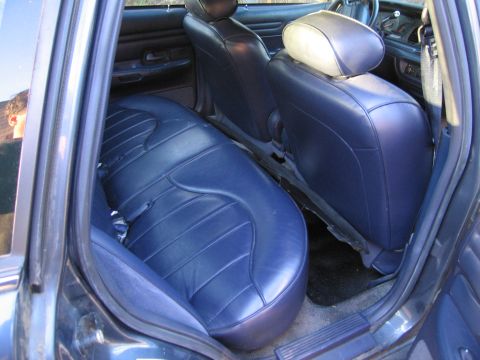 1991 Ford LTD Crown Victoria - The interior of the vehicle shows dark blue leather seats with a ribbed pattern.