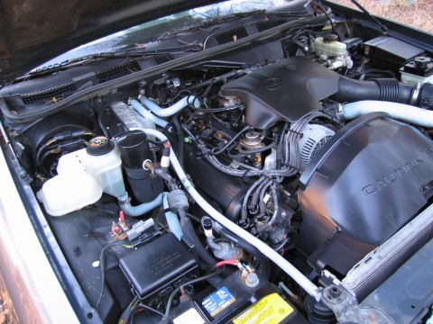 1991 Ford LTD Crown Victoria - The engine bay of a car, showing the V8 engine and associated parts.