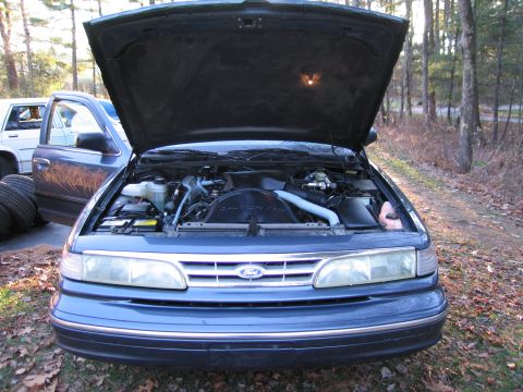 1991 Ford LTD Crown Victoria - Front view of a blue Ford Crown Victoria with its hood open, revealing the engine compartment.